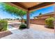 Inviting covered backyard patio featuring pavers, gravel, and lush green foliage at 6557 S Classic Way, Gilbert, AZ 85298
