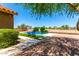 Stunning backyard pool area featuring a water feature, lounge chairs, and mature landscaping at 6557 S Classic Way, Gilbert, AZ 85298