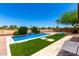 Backyard with a sparkling pool, artificial turf, and desert landscaping at 6557 S Classic Way, Gilbert, AZ 85298