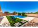 Beautiful backyard pool with lounge chairs and artificial grass surrounded by desert landscaping at 6557 S Classic Way, Gilbert, AZ 85298