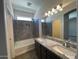 Modern bathroom with double sinks, granite countertops, and a luxurious shower-tub combination at 6557 S Classic Way, Gilbert, AZ 85298