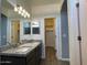 Well-lit bathroom featuring double sinks with granite counters, and access to a large walk-in closet at 6557 S Classic Way, Gilbert, AZ 85298