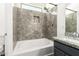 Bathroom featuring a tub with stylish tile surround, a shower head, and a granite countertop sink at 6557 S Classic Way, Gilbert, AZ 85298