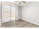 Bedroom with a ceiling fan, sliding door, and wood look flooring at 6557 S Classic Way, Gilbert, AZ 85298