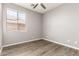Bedroom with a ceiling fan, window with blinds and wood look flooring at 6557 S Classic Way, Gilbert, AZ 85298