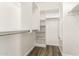 Walk-in closet with built-in shelving and racks with wood look flooring at 6557 S Classic Way, Gilbert, AZ 85298