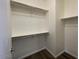 White walk-in closet with ample shelving and hanging space and wood-style floors at 6557 S Classic Way, Gilbert, AZ 85298