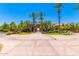 Clubhouse entrance featuring mature trees, desert landscaping, and arched entry to amenities beyond at 6557 S Classic Way, Gilbert, AZ 85298
