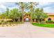Clubhouse entrance featuring mature trees, desert landscaping, and arched entry to amenities beyond at 6557 S Classic Way, Gilbert, AZ 85298