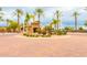 Inviting gated community entrance featuring palm trees, desert landscaping and roundabout at 6557 S Classic Way, Gilbert, AZ 85298