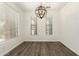Empty dining room with wood-look floors, neutral walls, and a modern chandelier at 6557 S Classic Way, Gilbert, AZ 85298