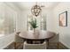 Stylish dining room showcasing a round table, upholstered chairs, wood-look floors, and contemporary lighting at 6557 S Classic Way, Gilbert, AZ 85298