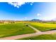 Expansive golf course with green grass, blue sky, and views of mountains in the distance at 6557 S Classic Way, Gilbert, AZ 85298