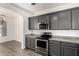 Stylish kitchen with granite countertops, stainless steel appliances, and gray cabinets at 6557 S Classic Way, Gilbert, AZ 85298