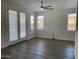 Bright living room with wood-look floors, ceiling fan, and access to the backyard through french doors at 6557 S Classic Way, Gilbert, AZ 85298