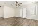 Open-concept living room with wood-look floors, a ceiling fan, and bright natural light at 6557 S Classic Way, Gilbert, AZ 85298