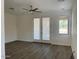 Bright living room with wood-look floors, ceiling fan, and access to the backyard through french doors at 6557 S Classic Way, Gilbert, AZ 85298