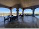 The patio has tables and chairs under a covered area, with views of the lush green lawns and distant hills at 6557 S Classic Way, Gilbert, AZ 85298