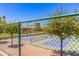 Pickle ball courts with lush green backdrop and gazebo as seen through green chain link fence at 6557 S Classic Way, Gilbert, AZ 85298