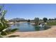 Scenic pond with a small waterfall, surrounded by lush greenery, landscaping and a mountain in the background at 6557 S Classic Way, Gilbert, AZ 85298