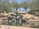 Picturesque water feature with small cascading waterfall and desert landscaping at 6557 S Classic Way, Gilbert, AZ 85298