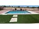 Backyard pool with waterfall feature, turf surround, and gravel landscaping at 6557 S Classic Way, Gilbert, AZ 85298