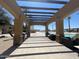 The view from a pergola looking toward the pool with chairs and palm trees creates a relaxing resort atmosphere at 6557 S Classic Way, Gilbert, AZ 85298