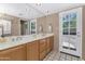 Bathroom with a large mirror, double sinks, and a door to the yard at 8666 E Cheryl Dr, Scottsdale, AZ 85258