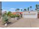 Home exterior with a two-car garage, mature landscaping, and a red tile roof under a blue sky at 8666 E Cheryl Dr, Scottsdale, AZ 85258