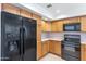 Kitchen featuring wood cabinets and black appliances at 8666 E Cheryl Dr, Scottsdale, AZ 85258