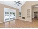 Bright living room with wood-look floors, fireplace, and doors leading to a pool area at 8666 E Cheryl Dr, Scottsdale, AZ 85258