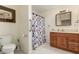 Functional bathroom featuring a vanity with storage, toilet, and shower with curtain at 11422 W Hidalgo Ave, Tolleson, AZ 85353