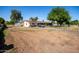 Expansive property featuring a single-story home with a large lot, driveway, and mature trees at 11422 W Hidalgo Ave, Tolleson, AZ 85353