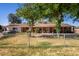 Charming single-story home featuring a chain-link fence, mature trees and a well-maintained lawn at 11422 W Hidalgo Ave, Tolleson, AZ 85353