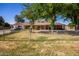 Charming single-story home featuring a chain-link fence, mature trees and a well-maintained lawn at 11422 W Hidalgo Ave, Tolleson, AZ 85353