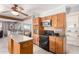 Efficient kitchen with wood cabinets, black appliances, and an island at 11422 W Hidalgo Ave, Tolleson, AZ 85353