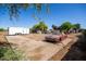 Expansive land with a concrete parking area, various structures, and an old red car at 11422 W Hidalgo Ave, Tolleson, AZ 85353