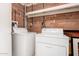 Simple laundry area with a washer and dryer against a brick wall, providing essential utility at 11422 W Hidalgo Ave, Tolleson, AZ 85353