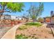 A large backyard with a concrete pathway, grass, decorative rock, and a large recreational vehicle at 1210 W Stottler Dr, Chandler, AZ 85224