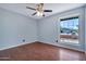 Bedroom with hardwood floors, a ceiling fan, and a large window overlooking the yard at 1210 W Stottler Dr, Chandler, AZ 85224