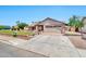 Single-story home with manicured lawn, brick accents, and a wide driveway leading to an attached two-car garage at 1210 W Stottler Dr, Chandler, AZ 85224