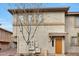 Tan townhome featuring an orange front door, beige trim and a small tree in the yard at 1225 N 36Th St # 2119, Phoenix, AZ 85008