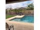 Backyard with a pool, patio area, turf, and a basketball hoop at 12518 W Milton Dr, Peoria, AZ 85383