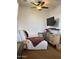 Bright bedroom with a cozy seating area and mounted TV at 12518 W Milton Dr, Peoria, AZ 85383