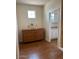 Hallway featuring light-colored walls, wood floors, a dresser, and an open door to the kitchen at 12518 W Milton Dr, Peoria, AZ 85383
