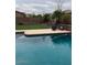 Backyard view of the pool with a patio, lounging chairs, and a basketball hoop at 12518 W Milton Dr, Peoria, AZ 85383