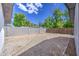 A spacious backyard features gravel, block fencing, and mature trees offering a serene outdoor space at 1263 W Devonshire St, Mesa, AZ 85201