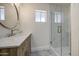 Bathroom featuring a vanity with modern fixtures, round mirror, hardware, and a glass-enclosed shower at 1263 W Devonshire St, Mesa, AZ 85201