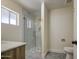 Bathroom featuring a glass-enclosed shower, marble tile, wood vanity, and new hardware fixtures at 1263 W Devonshire St, Mesa, AZ 85201