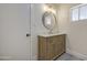 Bathroom featuring a vanity with modern fixtures, round mirror, vanity lighting, and hardware at 1263 W Devonshire St, Mesa, AZ 85201
